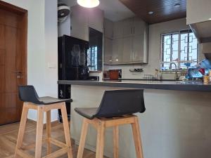 een keuken met twee krukken en een aanrecht bij 2 Bedroom Serviced Home in Lahore