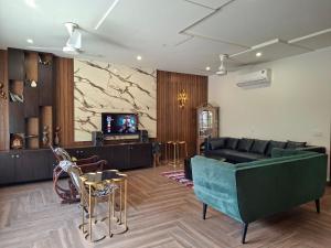 een woonkamer met een bank en een tv bij 2 Bedroom Serviced Home in Lahore
