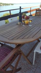 a wooden table with wine glasses and a bottle of wine at Apartment Ana in Kali