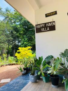 a sign that reads happy harvest villa next to plants at Happy Haven in Hikkaduwa