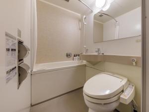 a bathroom with a toilet and a sink and a tub at Nishitetsu Hotel Croom Hakata in Fukuoka