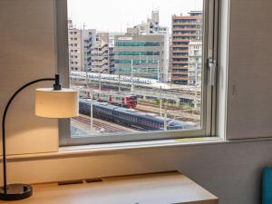 a window with a view of a train at Nishitetsu Hotel Croom Hakata in Fukuoka