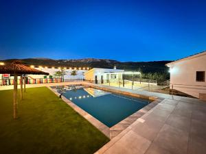 - une piscine dans la cour d'une maison la nuit dans l'établissement La Villa de Alba - Casa Rural en Montefrío, à Montefrío