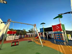 une aire de jeux pour enfants avec un toboggan et des balançoires dans l'établissement La Villa de Alba - Casa Rural en Montefrío, à Montefrío