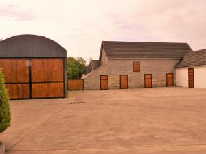 dos graneros con puertas de madera y un edificio en Belle View House Self Catering, en Mohill