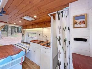 a kitchen in a tiny house with a sink at Tenerife Stylish Camper Van with Bathroom in Arona +12 photos