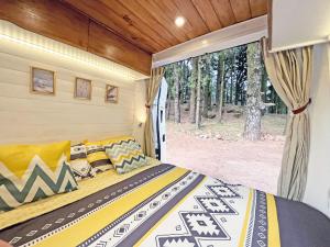 a bed in a small room with a window at Tenerife Stylish Camper Van with Bathroom in Arona