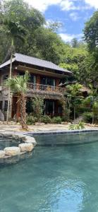 ein Haus mit einem Fluss davor in der Unterkunft Mai Chau Sunrise Village in Mai Châu