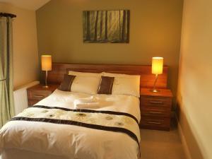a bedroom with a large bed with two lamps at Belle View House Self Catering in Mohill