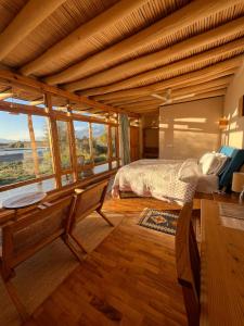 een slaapkamer met een bed in een kamer met ramen bij The Indus River Camp in Leh