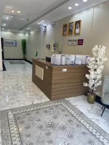 a lobby with a reception desk and a tree at غولدن إليت للشقق المخدومة الأجاويد Golden Elite Serviced apartment alajawed in Jeddah
