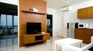 un salon avec une télévision sur un mur en bois dans l'établissement Pannapat Place, à Bangkok