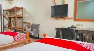 een slaapkamer met een bed, een bureau en een televisie bij 900 Inn in Bintulu