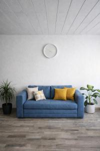 a blue couch in a room with a clock on the wall at Weserbutze in Bodenwerder