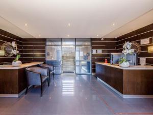 een lobby met een bar met stoelen en tafels bij Infinity Self Catering Apartments in Bloubergstrand