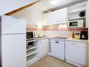 una cucina con mobili bianchi e un frigorifero di Haut du Lac I N205 3P6 a Homps Altre 5 foto