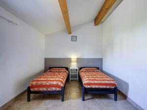 due letti in una stanza con pareti bianche di Haut du Lac I N205 3P6 a Homps