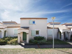 una casa bianca con porte verdi e un lampione di Haut du Lac I N205 3P6 a Homps