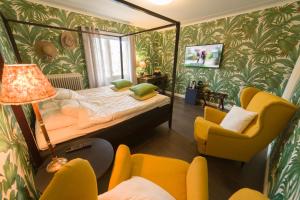 um pequeno quarto com uma cama e uma cadeira em Hotell Stensborg em Skellefteå