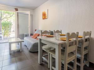 a dining room with a table and chairs and a bed at D du Ventoux D N55 3P6 in Aubignan