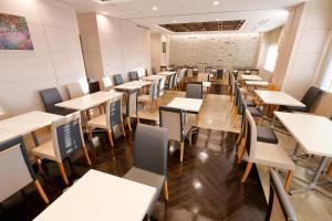 una sala da pranzo vuota con tavoli e sedie di Richmond Hotel Premier Musashikosugi a Kawasaki