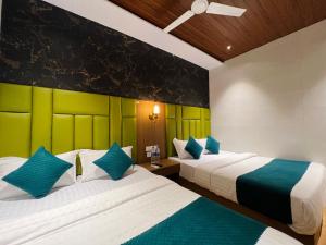 two beds in a room with green and white at Hotel Imperial Suite-Near BKC in Mumbai