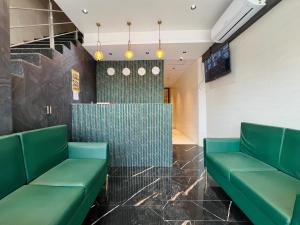 a waiting room with green benches and a counter at Hotel Imperial Suite-Near BKC in Mumbai