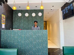 a man standing behind a counter in a restaurant at Hotel Imperial Suite-Near BKC in Mumbai