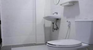 a white bathroom with a toilet and a sink at Nan Lanna Hotel in Nan