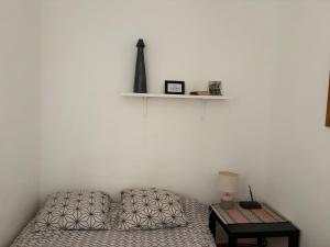 a bedroom with a bed and a table with a shelf at Petit studio haussmannien in Marseille