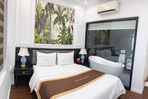 een slaapkamer met een bed en een bad bij Royal Hotel Hà Nội in Hanoi