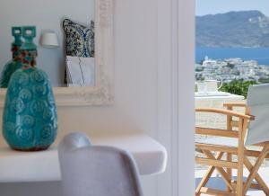 een kamer met een spiegel, een stoel en een vaas bij Lithos Luxury Rooms (Adults Only) in Adamas