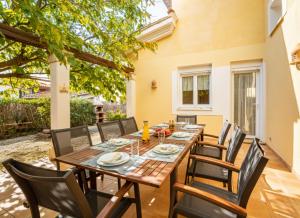 a dining room with a wooden table and chairs at Ideal Property Mallorca - Villa Feel Good in Alcudia