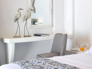 een slaapkamer met een bureau waarop twee vogels zitten bij Lithos Luxury Rooms (Adults Only) in Adamas +13 foto's