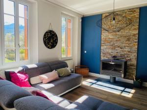 een woonkamer met een bank en een open haard bij La Villa Madeleine in Jausiers