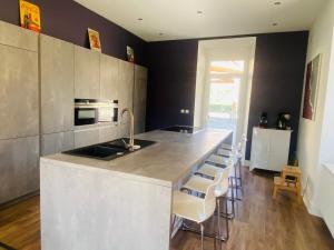 een keuken met een aanrecht met een wastafel en een aantal stoelen bij La Villa Madeleine in Jausiers