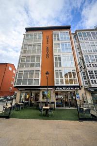 布尔戈斯洛斯布拉瑟洛斯中心酒店的一座建筑物，前面有一张桌子和几把椅子