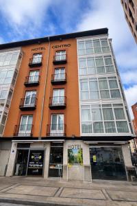 布尔戈斯洛斯布拉瑟洛斯中心酒店的一座大型橙色建筑,与酒店同建