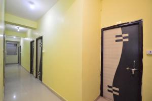 een rij deuren in een gang met gele muren bij Hotel O Reyansh Galaxy in Kota