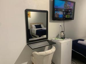 een spiegel aan de muur van een kamer met een bed bij 103-Quarto Pousada HG in Vila Nova do Sul
