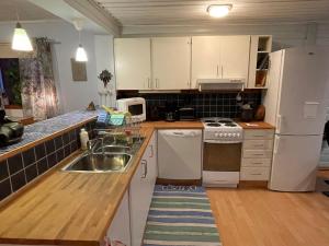 eine Küche mit Spüle und einem weißen Kühlschrank in der Unterkunft Litet hus utanför Luleå in Luleå