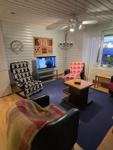 ein Wohnzimmer mit Stühlen, einem TV und einem Tisch in der Unterkunft Litet hus utanför Luleå in Luleå