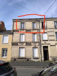 ein Gebäude mit einem orangefarbenen Band an der Seite in der Unterkunft Le 6, bedandberry private parking in Châteauroux