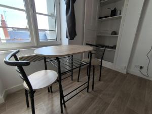 einen Tisch und Stühle in einer Küche mit Fenster in der Unterkunft Le 6, bedandberry private parking in Châteauroux