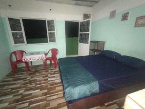 une chambre avec un lit, une table et des chaises dans l'établissement Pousada Nan, à Salvador 2 autres photos