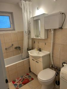 een badkamer met toilet, wastafel en bad bij Apartman Borkica in Mladenovac