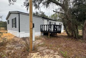 une petite maison avec une terrasse couverte et un poteau dans l'établissement Beautiful two bedroom house, à Lake Wales