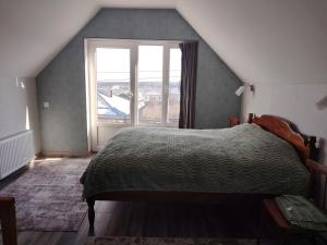 ein Schlafzimmer mit einem Bett und einem großen Fenster in der Unterkunft AGA Frame in Qusar