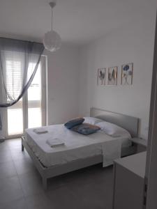 een witte slaapkamer met een bed en een raam bij Marie Plus In Centro in Capo dʼOrlando