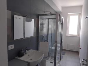 een badkamer met een glazen douche en een wastafel bij Marie Plus In Centro in Capo dʼOrlando